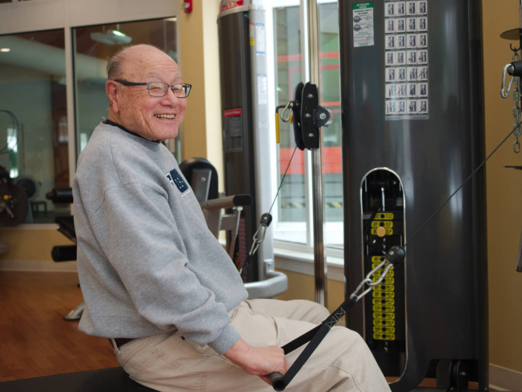 man smiling while using fitness machine 
