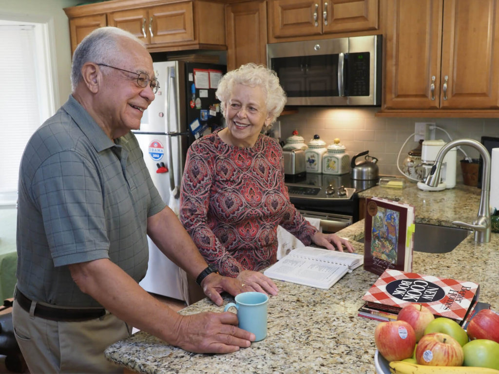 man and woman standing by kitchen counter 