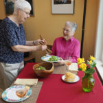 senior women eating salad and wine