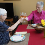 two senior women drinking wine