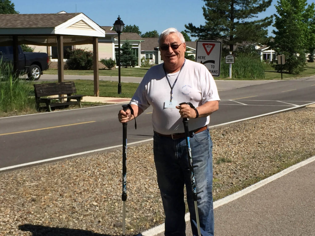 man smiling with walking poles 