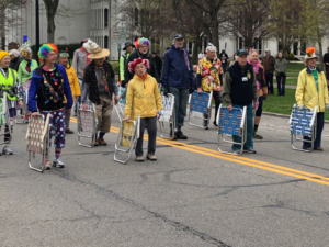 group of people carrying lawn chairs