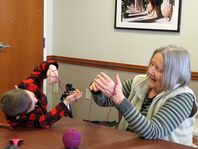 boy with older woman - playing cat's cradle