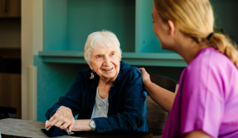 older woman sitting with nurse