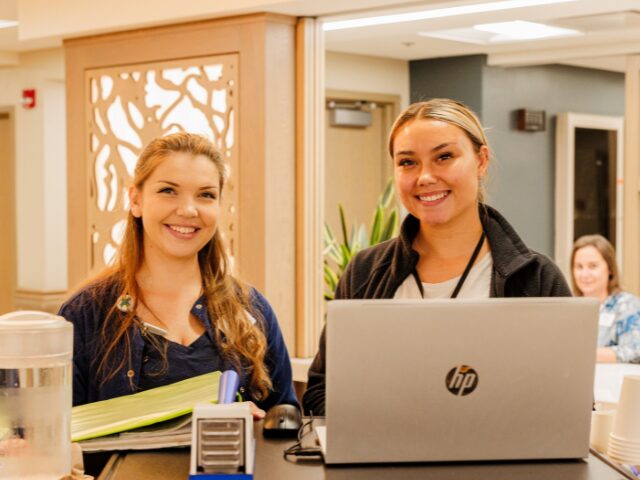 two nurses standing at nursing cart 