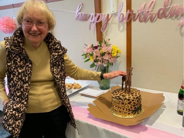woman standing next to birthday cake