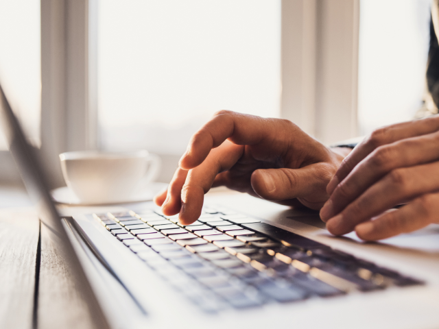 hands typing on computer