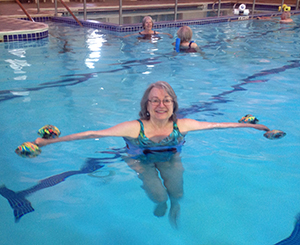 Older woman swimming in the pool to keep her heart in shape.