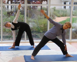 2 older adult women doing yoga